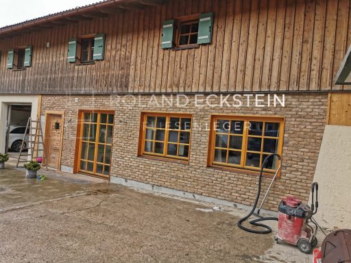 Fachwerkhaus mit Holz- und Steinfassade, Fenstern und Eingangstüren.