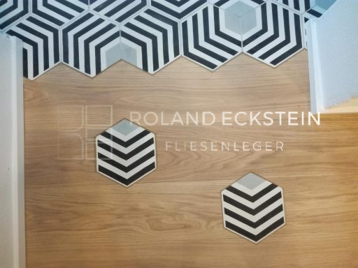Boden mit Holzoptik und geometrischen Fliesen in Schwarz-Weiß-Muster.