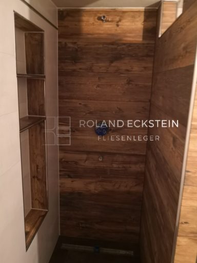 Holzvertäfelte Wand mit Nische und Regal im Innenraum.