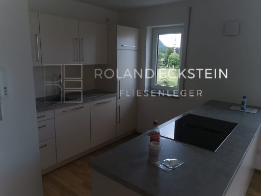 Helle moderne Küche mit einer Kochinsel und weißen Schränken.