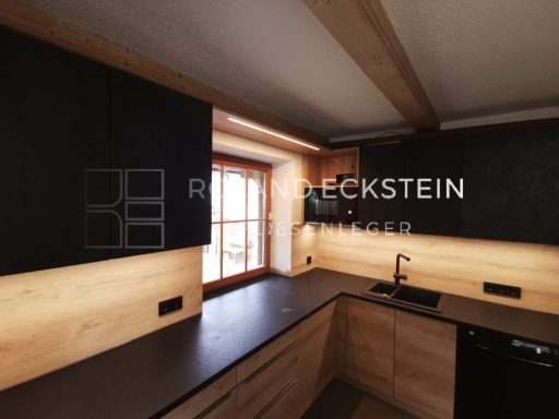Moderne Küche mit Holzpaneelen, dunklen Schränken und Fenstern, die natürliches Licht bringen.