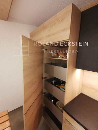 Holzschrank mit offenen Türen, Ablagen für Getränke und Lebensmittel sichtbar.